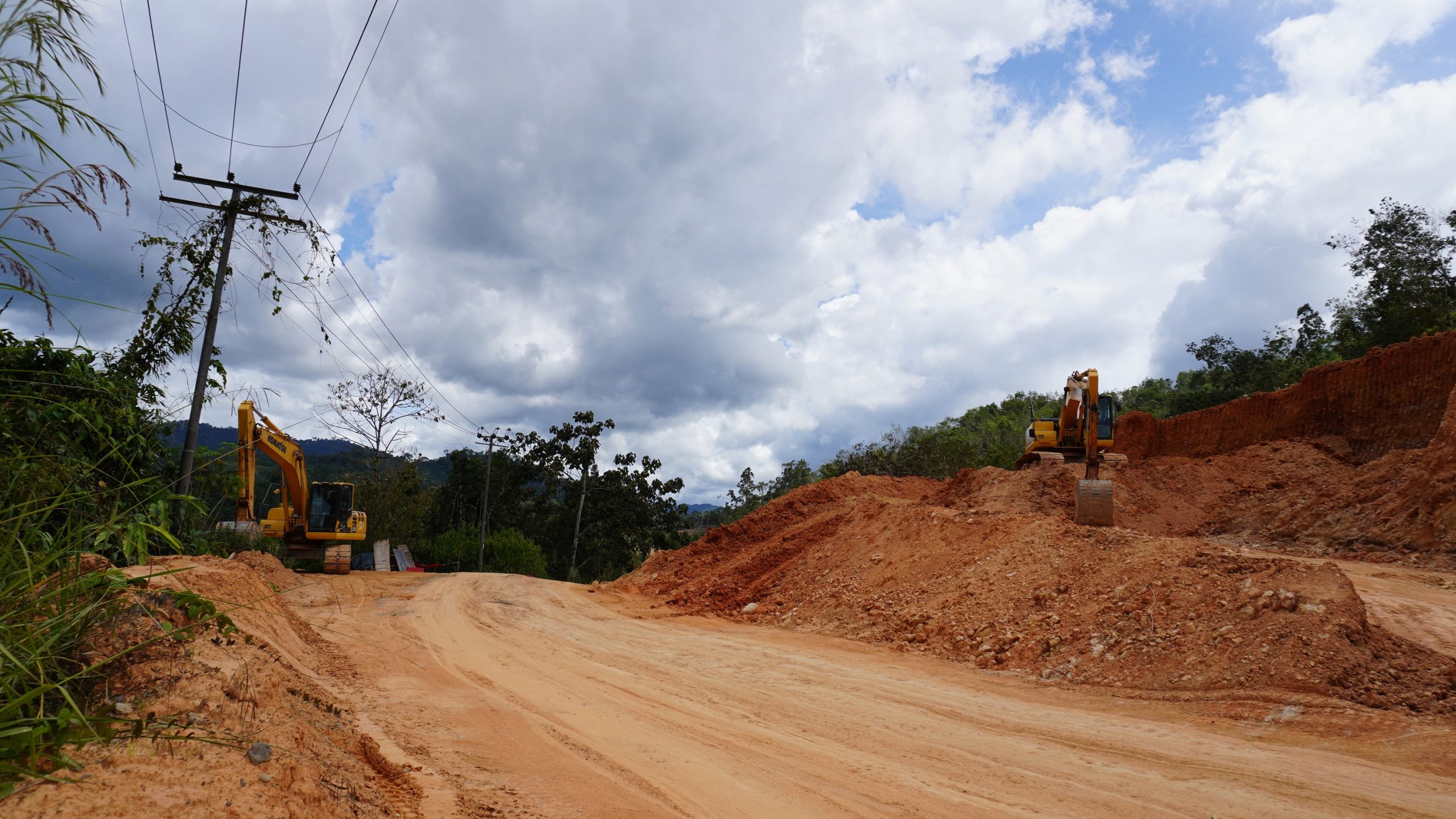 เครื่องจักรกำลังทำงาน เปิดถนนเข้าสู่หมู่บ้านและสวนปาล์ม