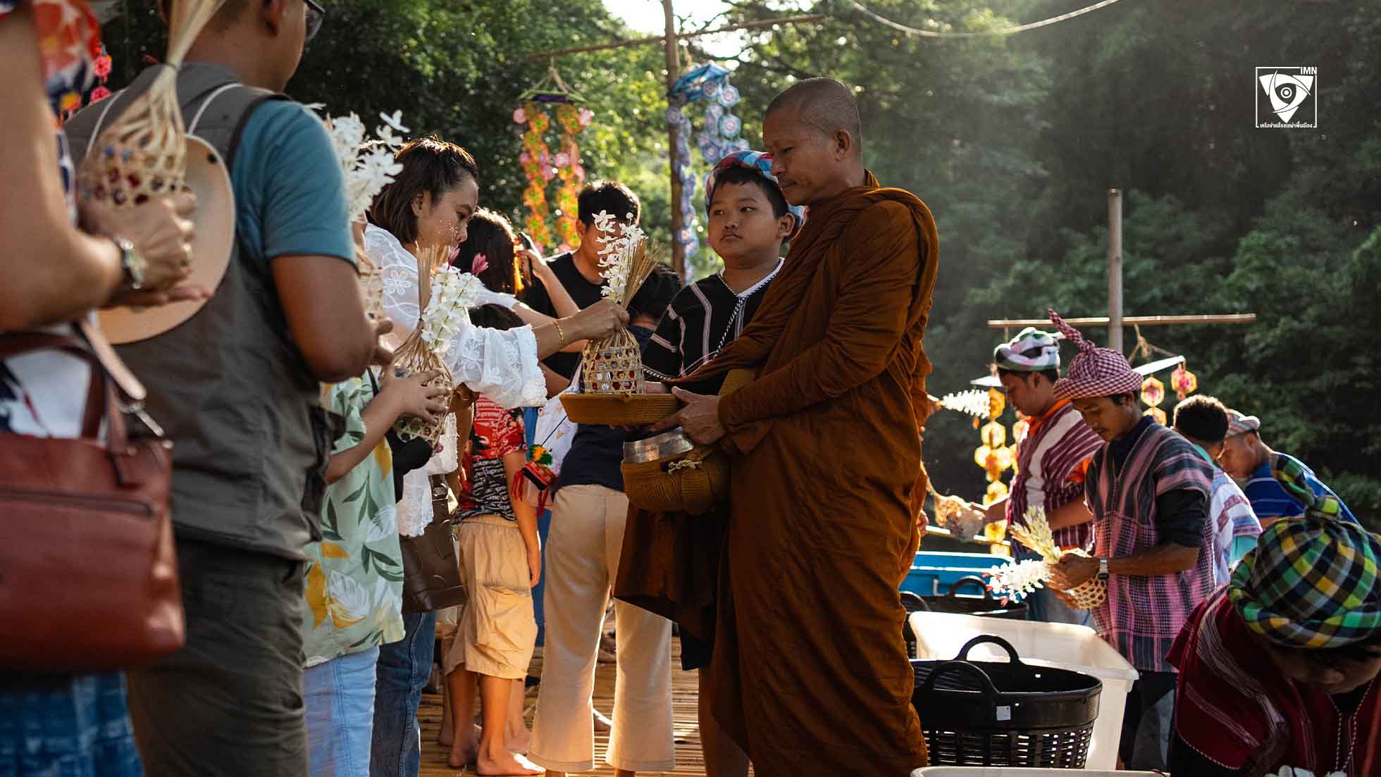 ชาวบ้านปกาเกอะญอและนักท่องเที่ยวร่วมทำบุญตักบาตรด้วยกัน ณ ตลาดโอ๊ะป่อย ตั้งอยู่ติดลำน้ำภาชี อ.สวนผึ้ง จ.ราชบุรี ภาพ: IMN-เครือข่ายสื่อชนเผ่าพื้นเมือง
